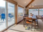 The dining table is next to the sliding glass door and large windows offering another look at the ocean.